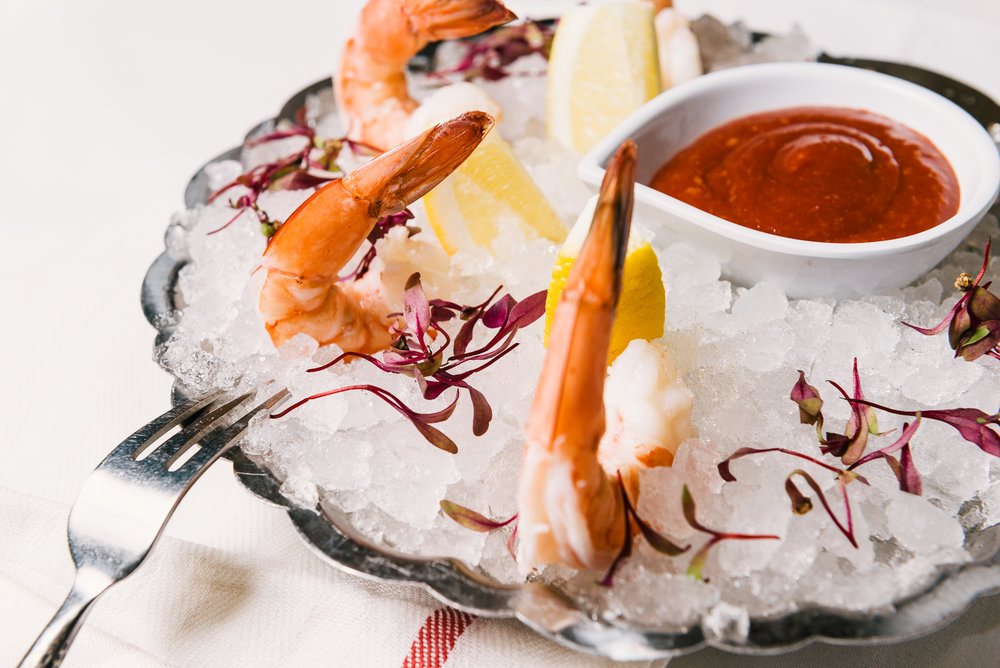 Shrimp cocktail presented on a silver dish over ice